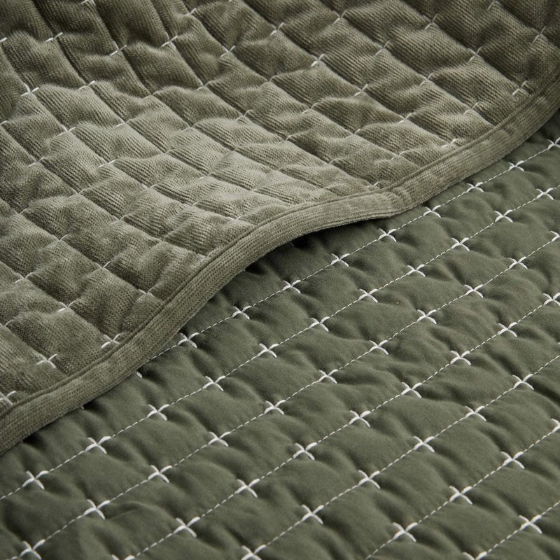 ciemno zielona narzuta na kanapę i łóżko