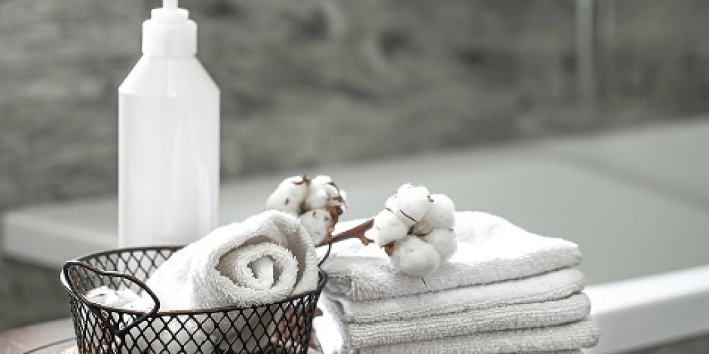 reczniki-lazienkowe-biale ręczniki łazienkowe elegancko wyeksponowane obok wanny